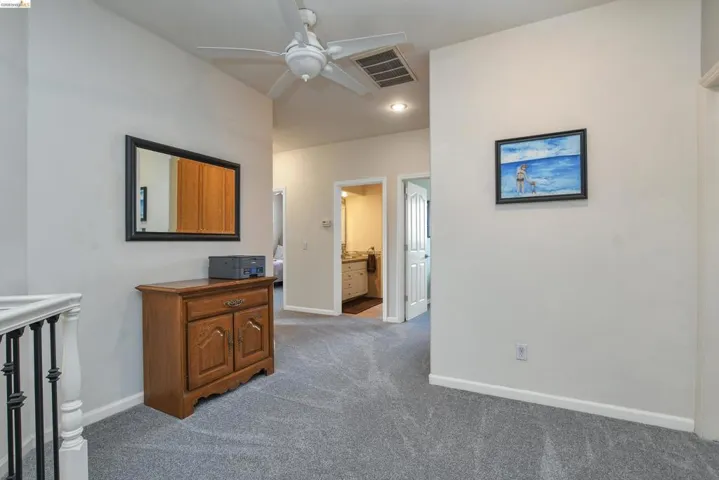 Hallway featuring baseboards and dark colored carpet