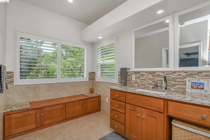 Full bathroom with vanity, healthy amount of natural light, light tile patterned flooring, and recessed lighting