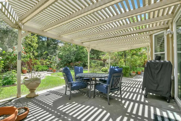 Fenced backyard featuring a patio, area for grilling, outdoor dining space, and a pergola
