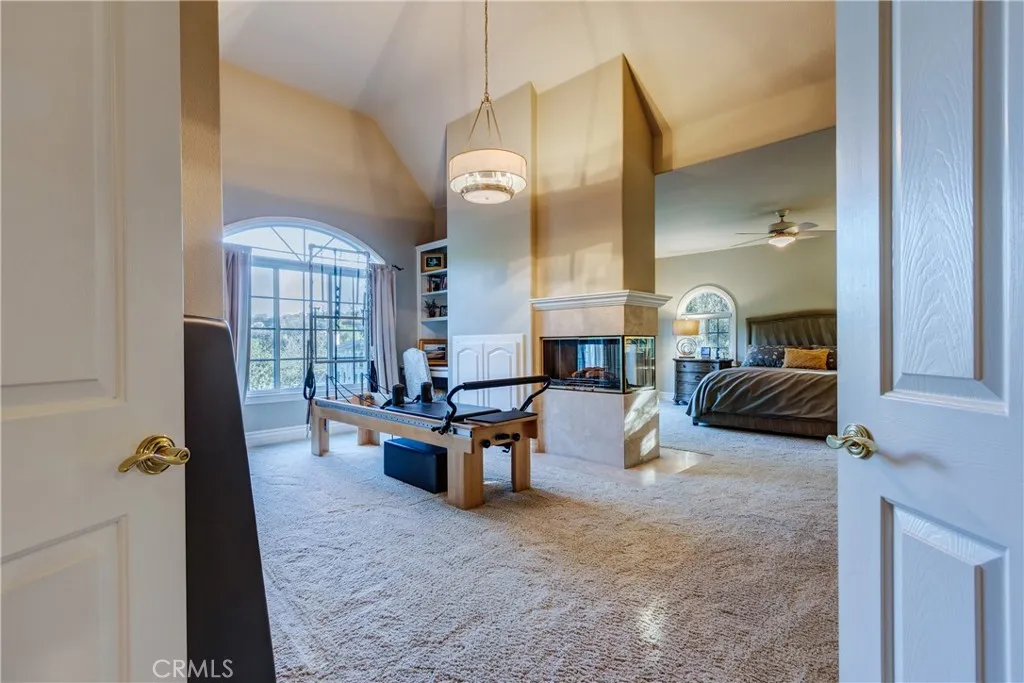Entry into primary suite and sitting/work-out room w see-through fireplace