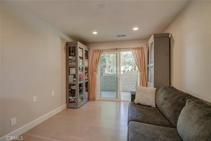 Second bedroom with vinyl flooring and slider, custom lighting. Light and bright! Easy access to patio area