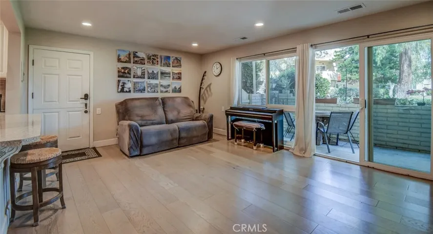 View to front door from entry to living room from kitchen and dining area. Note the serene setting outside!