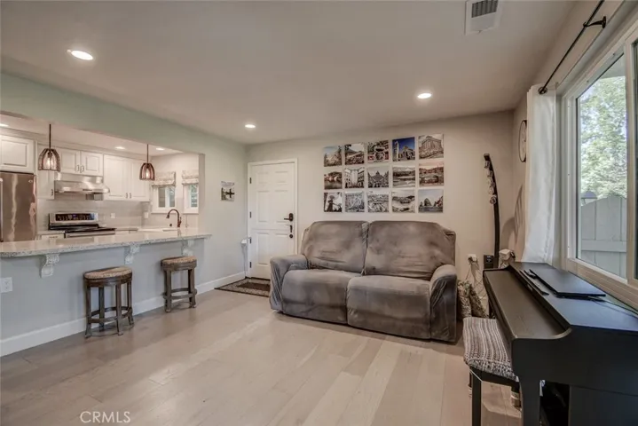 Living room showing adjacent easy-access kitchen with "barstool seating". Kitchen has been opened up to give the  area more of a "great room" effect