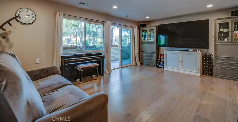 Living room showing light and bright with all vinyl replaced sliders, nice vinyl flooring upgrade and recessed lighting