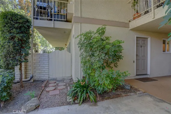 Mature landscaping near front door and gate to patio