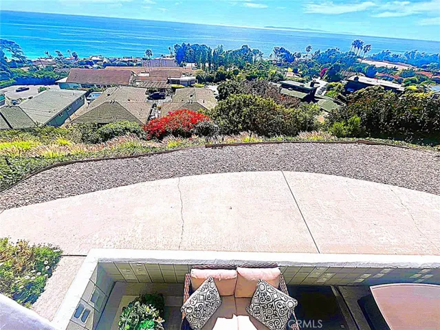 Bird's eye view looking down at the condo's patio with the ocean view in the background.