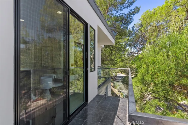Bedroom balcony with sleek glass railings.