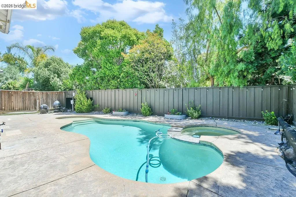 Freeform swimming pool featuring an integrated spa