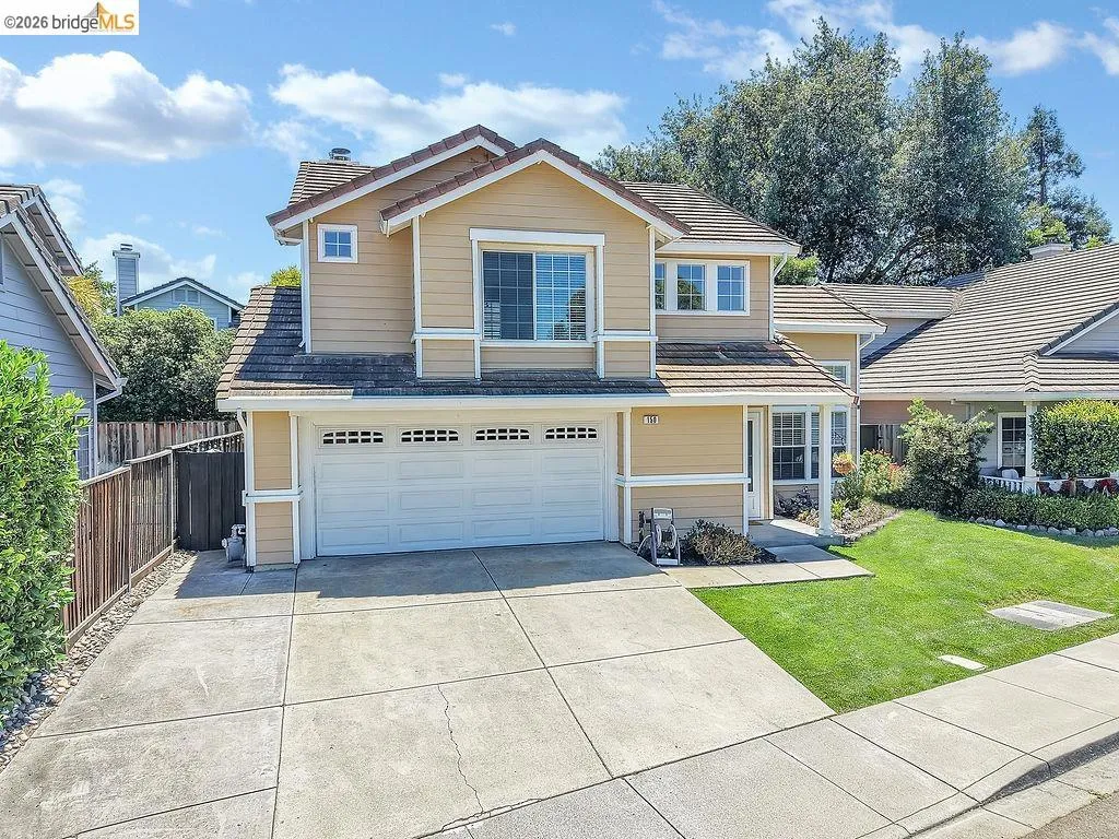 Two-story residence featuring a tile roof, light-colored siding, and white trim