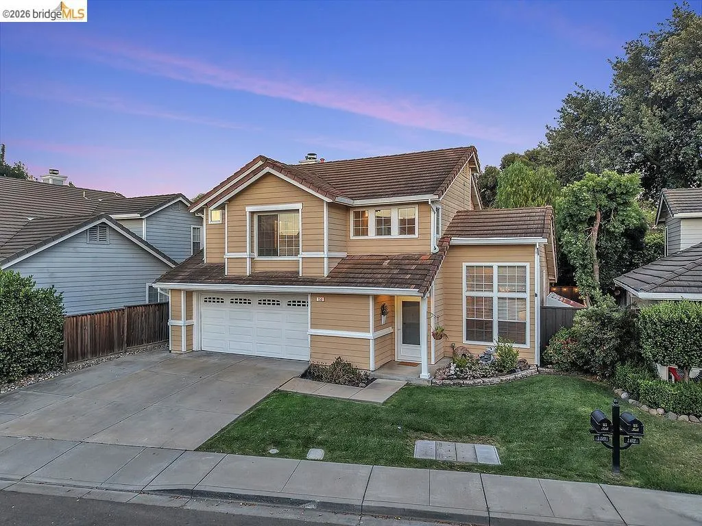 Two-story residence featuring a two-car garage, concrete driveway, and a gabled roofline