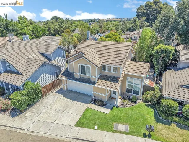 Two-story residence with a tan exterior and brown tile roof