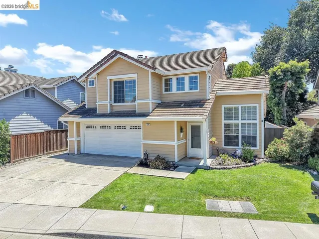 Two-story residence featuring a tile roof, light-colored siding, and white trim