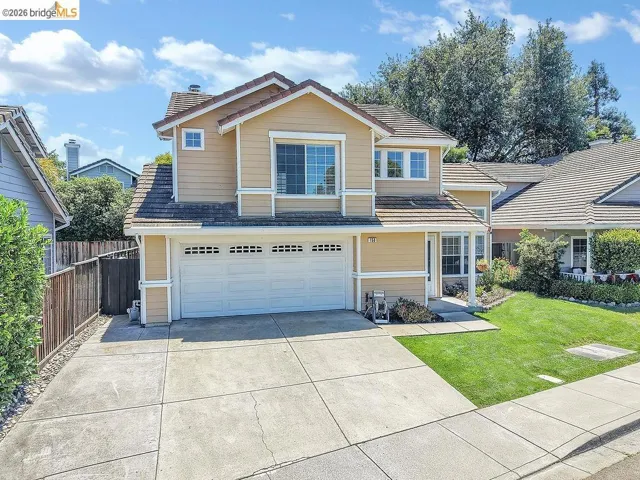 Two-story residence featuring a tile roof, light-colored siding, and white trim