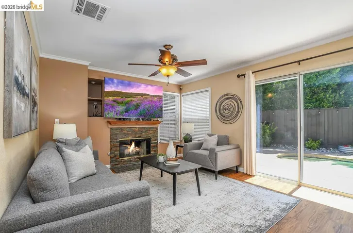 Living area with a stone-faced fireplace, wood mantel, and built-in shelving