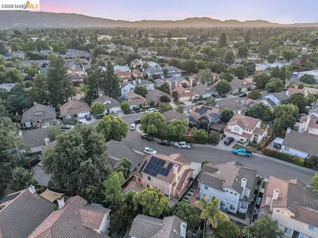 Residential neighborhood featuring a variety of architectural styles, mature trees, and a mountain backdrop