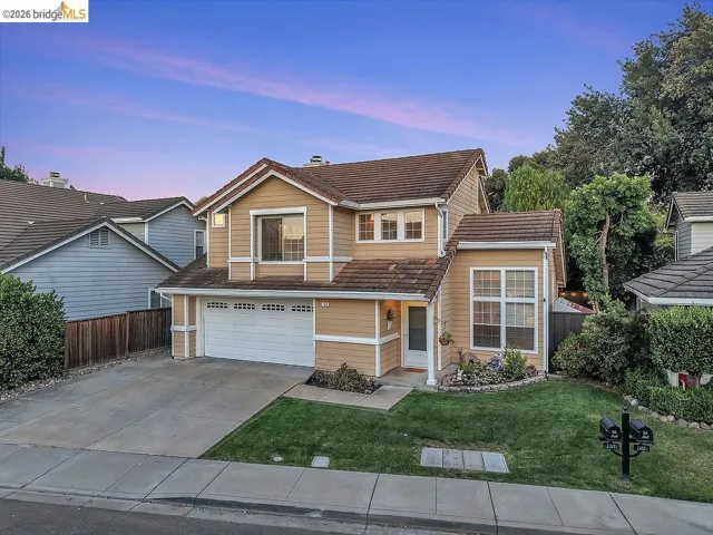 Two-story residence featuring a two-car garage, concrete driveway, and a gabled roofline