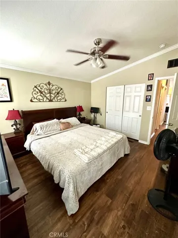 Primary bedroom with fan and crown molding