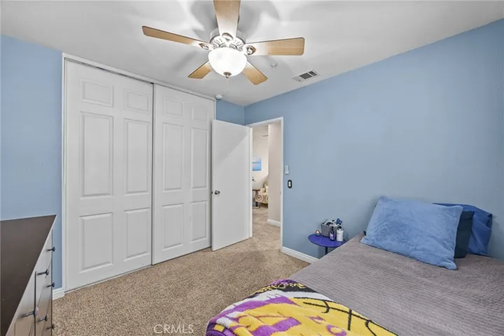 Second spacious bedroom with tall paneled closet doors.