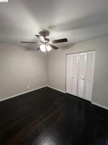 Unfurnished bedroom with dark wood finished floors, a closet, and ceiling fan