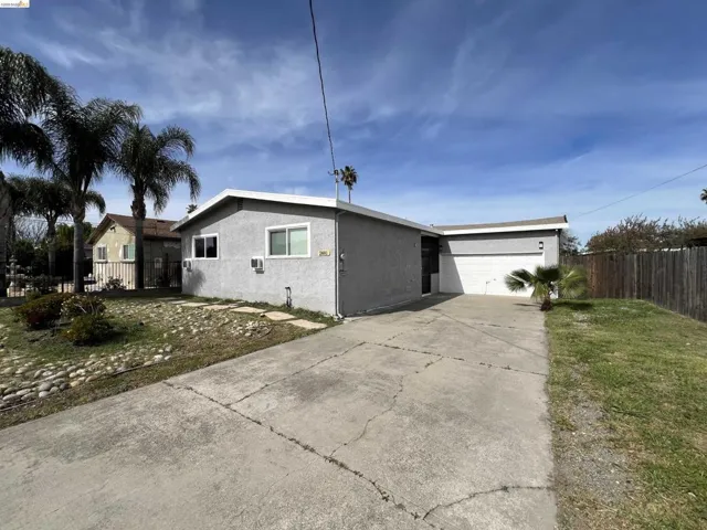 View of front facade with an attached garage, concrete driveway, and stucco siding