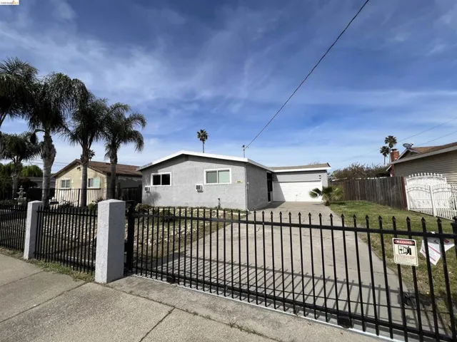 View of front of home featuring a fenced front yard, an attached garage, stucco siding, and driveway