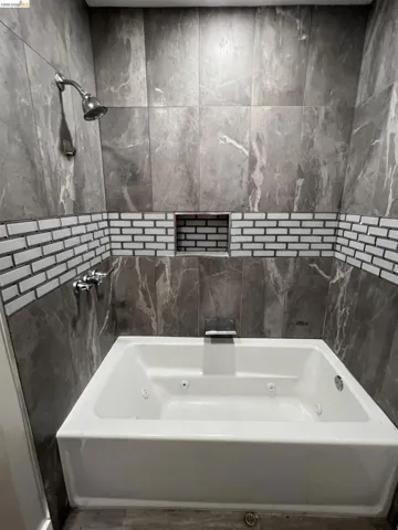 Bathroom featuring a combined bath / shower with jetted tub