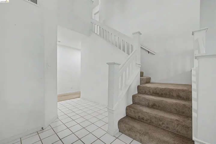 Stairs with tile patterned floors and a high ceiling