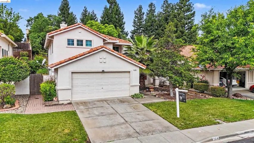 Mediterranean / spanish house with driveway, a front yard, stucco siding, a chimney, and a tile roof