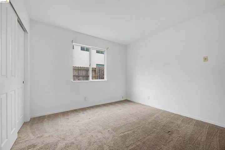 Unfurnished bedroom with light colored carpet and a closet