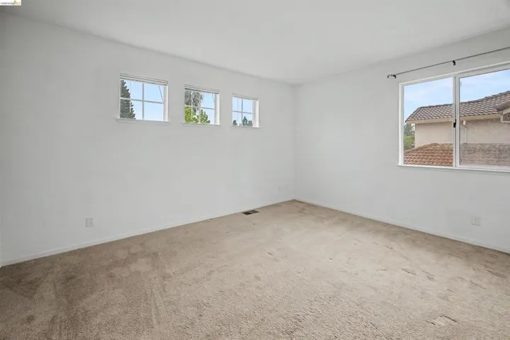 Unfurnished room featuring healthy amount of natural light and carpet flooring