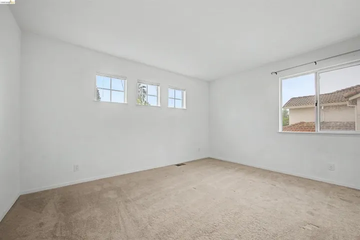 Carpeted spare room featuring baseboards