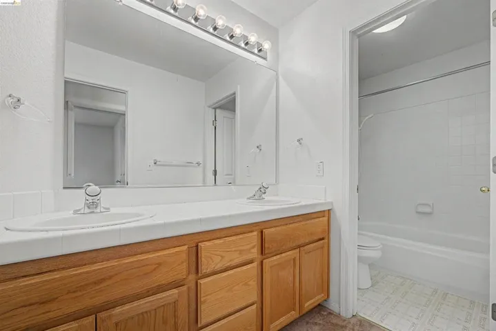 Full bath with double vanity and tub / shower combination