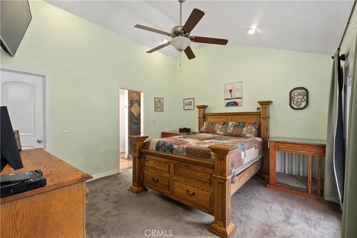 Primary bedroom with patio access, ensuite, & walk-in closet.