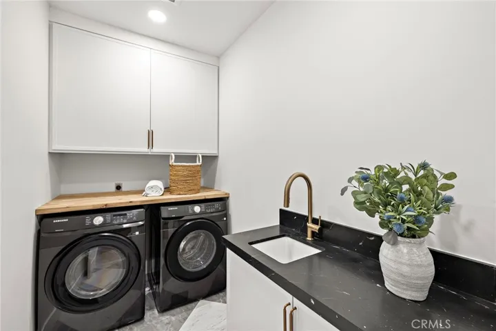Upstairs laundry room with two folding areas and 4 large storage cabinets