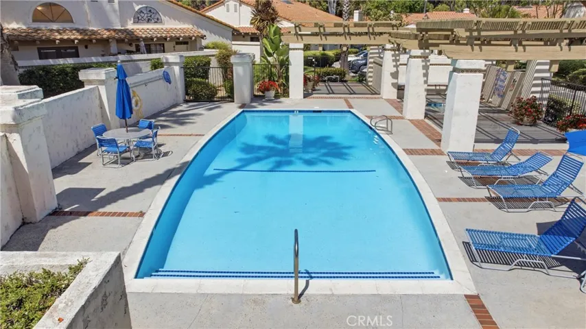 Resort-style community pool area featuring lounge seating, open deck space, and a tranquil setting. Perfect for relaxing, entertaining, and enjoying sunny days just steps from​​‌​​​​‌​​‌‌​​‌​​​‌‌​​​‌​​‌‌​​‌‌​​‌‌​​​​ home.