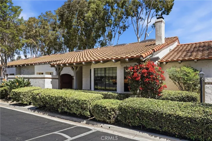 Charming Spanish-style exterior with classic clay tile roof, mature landscaping, and lush hedges creating a private and welcoming curb appeal. Situated along a peaceful interior street, this home offers timeless character with a well-maintained façade and inviting presence.