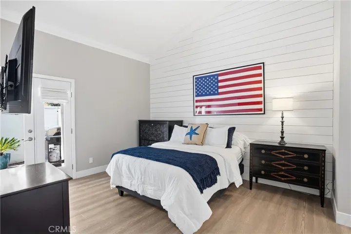 Spacious bedroom with upgraded flooring, stylish accent wall, and abundant natural light. Offers flexibility for a primary suite, guest room, or additional living space.