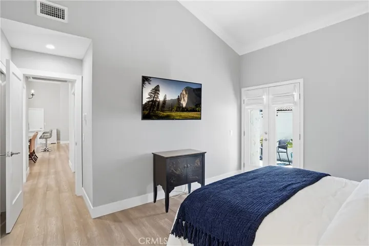 Bright and airy bedroom featuring vaulted ceilings, natural light, and direct access to a private outdoor space. The functional layout and indoor-outdoor connection create a comfortable and inviting retreat.