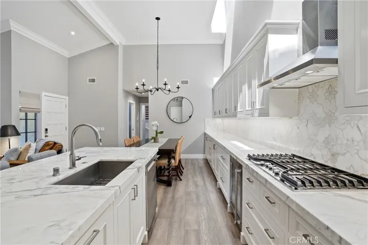 Expansive kitchen layout with extended counter space, custom cabinetry, and designer backsplash. The open sightline toward the dining and living areas enhances the home’s seamless flow, ideal for entertaining.