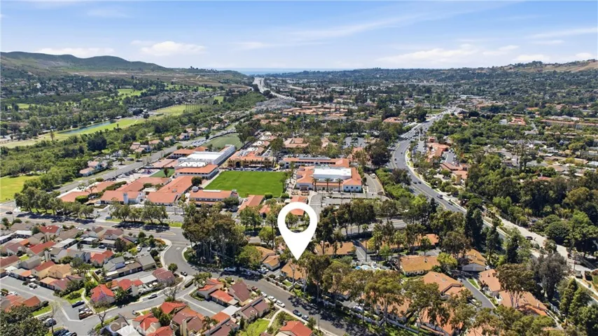 Expansive aerial view capturing the surrounding area, rolling hills, and distant ocean views. Ideally located with convenient access to local shopping, dining, and coastal attractions.