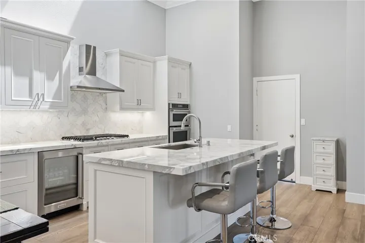 Beautifully designed kitchen with oversized island, quartz countertops, shaker cabinetry, and stainless steel appliances. Includes bar seating, double ovens, and ample prep space, combining style and functionality for everyday living.
