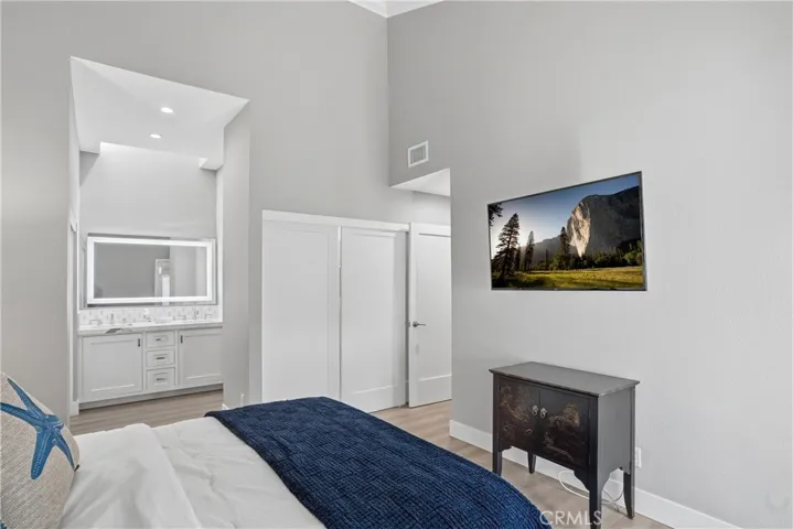 Spacious bedroom with high ceilings, neutral tones, and an open layout leading into the en-suite vanity area. Designed for comfort and flow, offering a seamless transition between living and private spaces.
