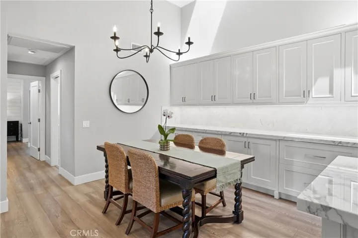Dedicated dining area featuring vaulted ceilings, elegant lighting, and custom built-in cabinetry offering additional storage and serving space. Positioned adjacent to the kitchen, this space is perfect for both everyday dining and entertaining.
