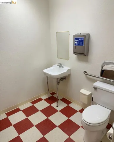 bathroom with toilet and light flooring
