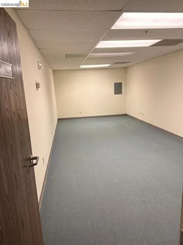 spare room with dark carpet, a paneled ceiling, and electric​​‌​​​​‌​​‌‌​​‌​​​‌‌​​​‌​​‌‌​​‌‌​​‌‌​​​​ panel