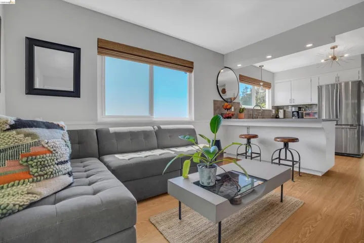 Living area with light wood finished floors and recessed lighting