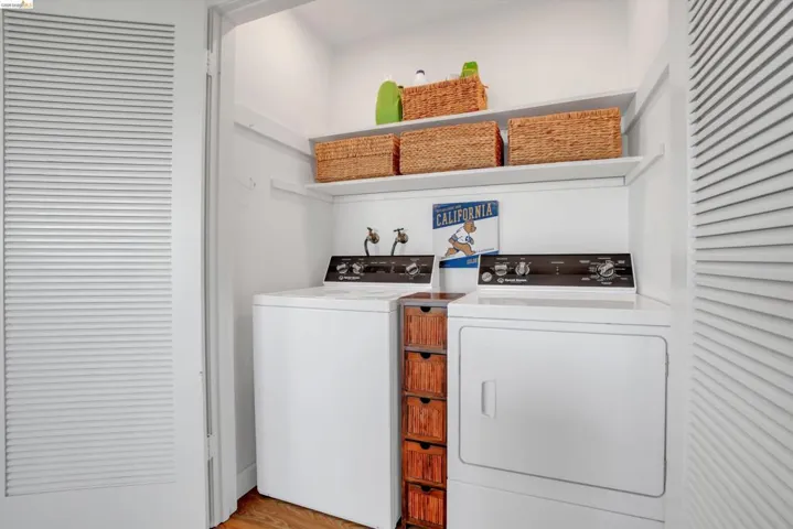 Laundry area with light wood-style flooring and washer and clothes dryer