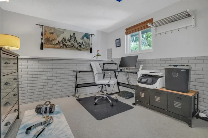 Office with wainscoting, tile walls, and light colored carpet