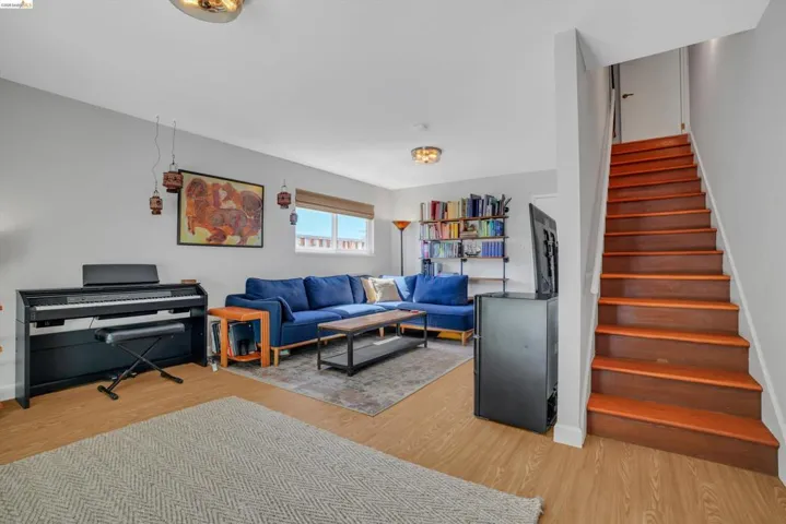 Living room featuring light wood-type flooring and stairs