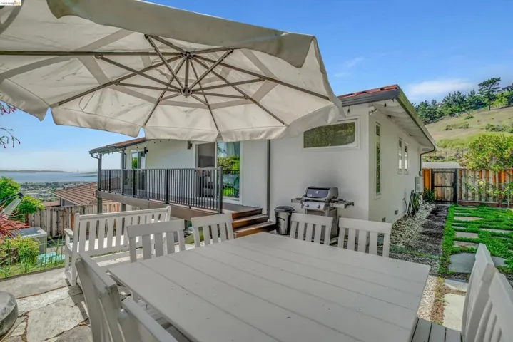 Wooden deck with outdoor dining area, grilling area, and a patio